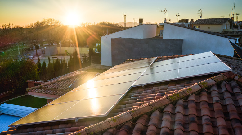 Roof with solar panel during sunset.