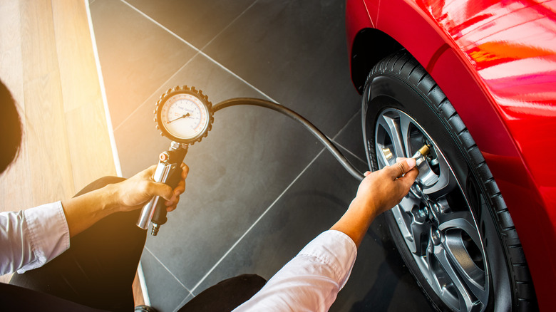 Man using dial tire pressure gauge