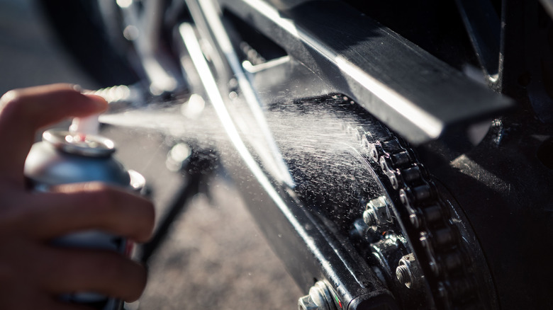 Spraying lubricant on motorcycle