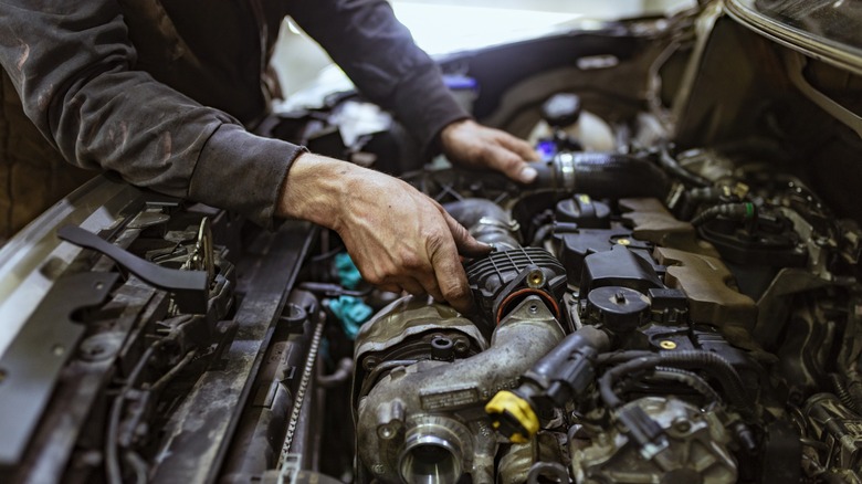 Dirty engine worked on by mechanic