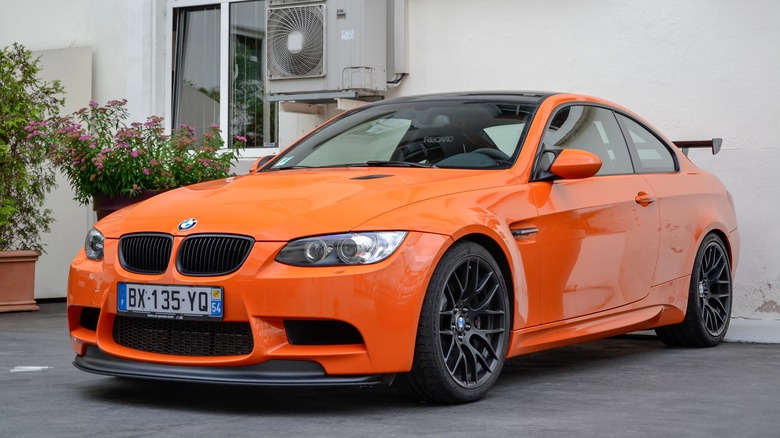 Orange 2012 BMW M3 parked in a driveway