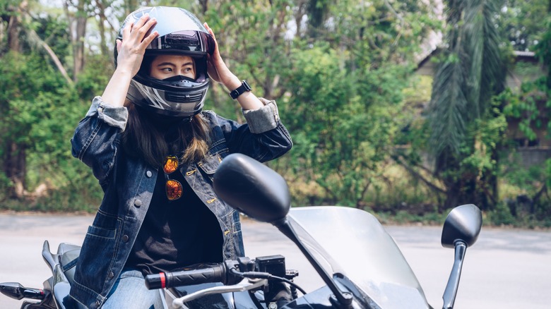 motorcyclist putting on helmet