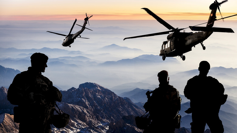 Soldiers watching helicopters at dusk