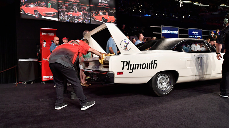 People cleaning display Plymouth Superbird