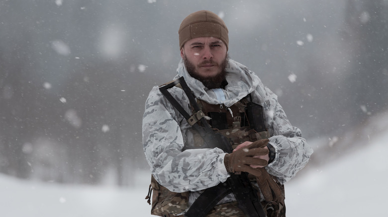 Camouflaged soldier in winter environment