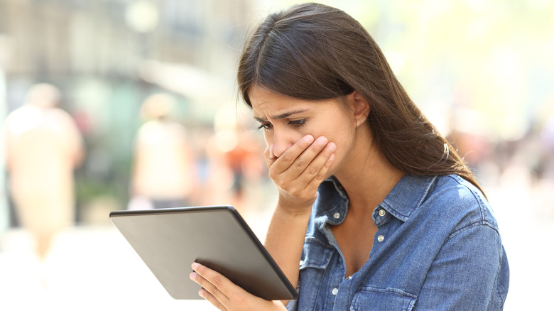 agitated woman reading tablet