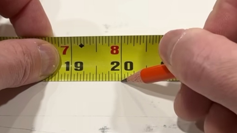 Marking the material at 20 inches with a pencil.