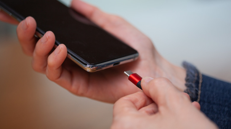 plugging cable into smartphone