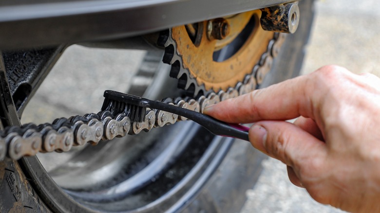 Cleaning motorcycle chain with a soft brush