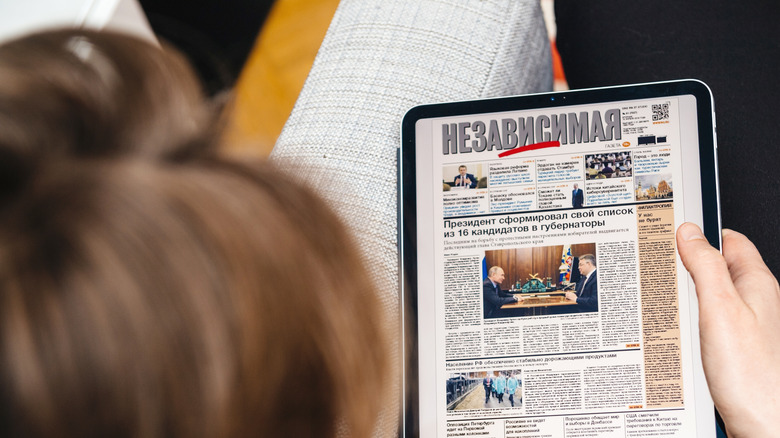 person using iPad Pro to read news