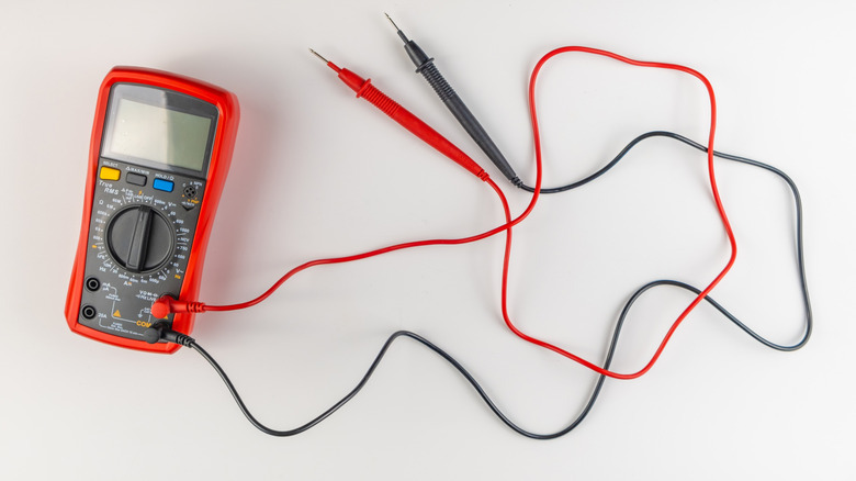 Red multimeter on a table with leads