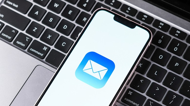 iPhone with Mail app sitting on MacBook keyboard
