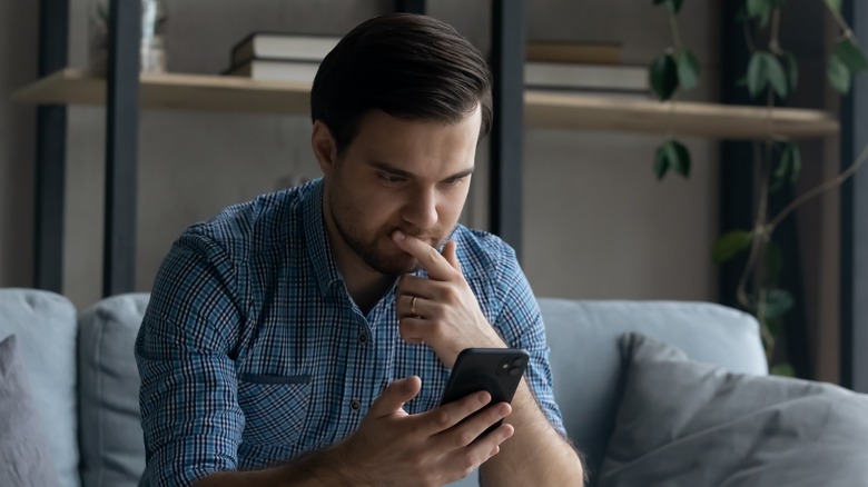 man using iphone serious face