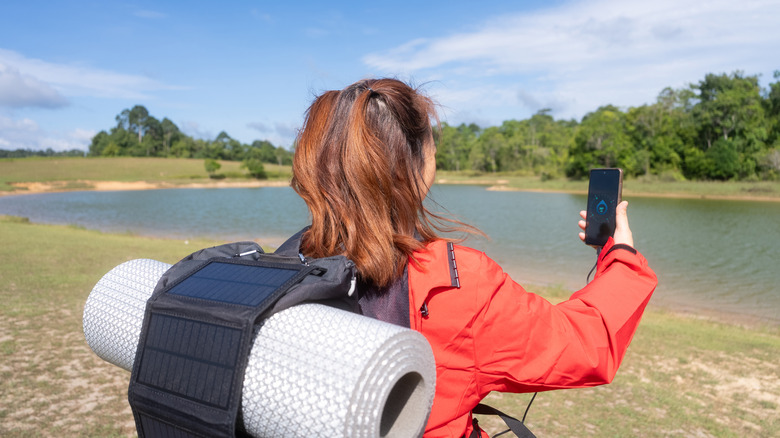 Woman using compass on phone to find location