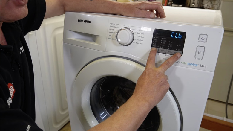 Man putting a Samsung washing machine in calibration mode