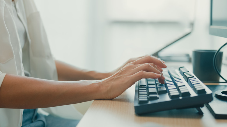 Person typing on keyboard