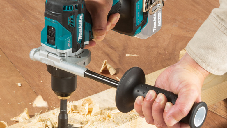 Person using hammer drill on wood