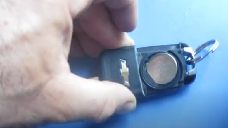 A battery is placed into an older Chevrolet key fob