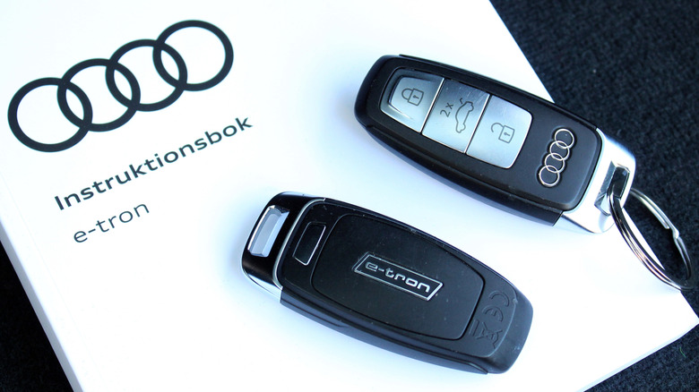 Two Audi key fobs on top of owners manual