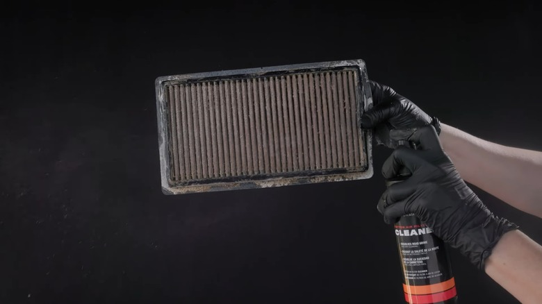 person cleaning k&n engine air filter