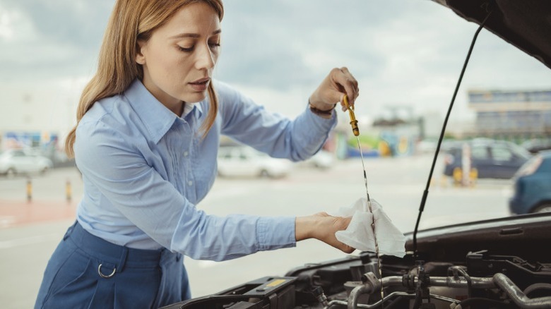 A person checking their engine oil dipstick