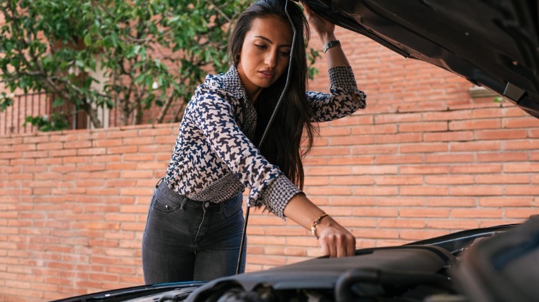 A person looking at their engine bay and preparing to change their oil