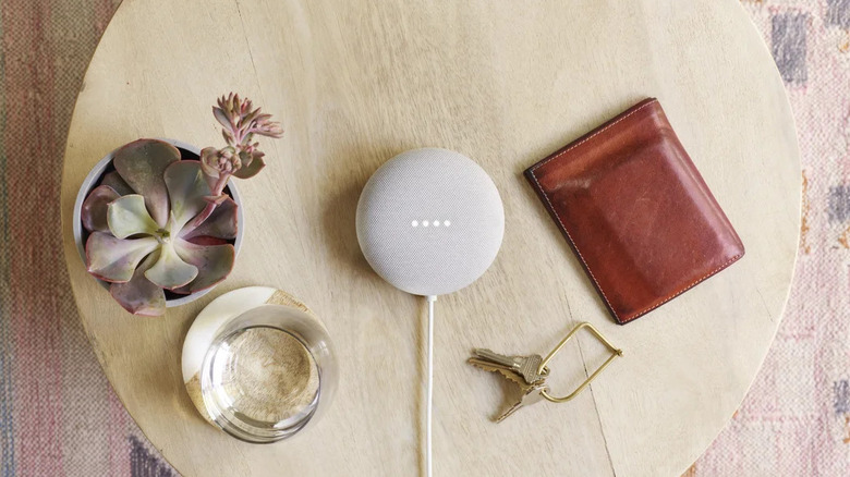 Nest mini speaker on table with items