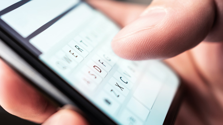 closeup of person typing on smartphone keyboard