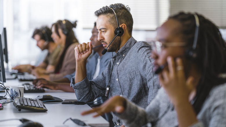 people on headsets in front of computer