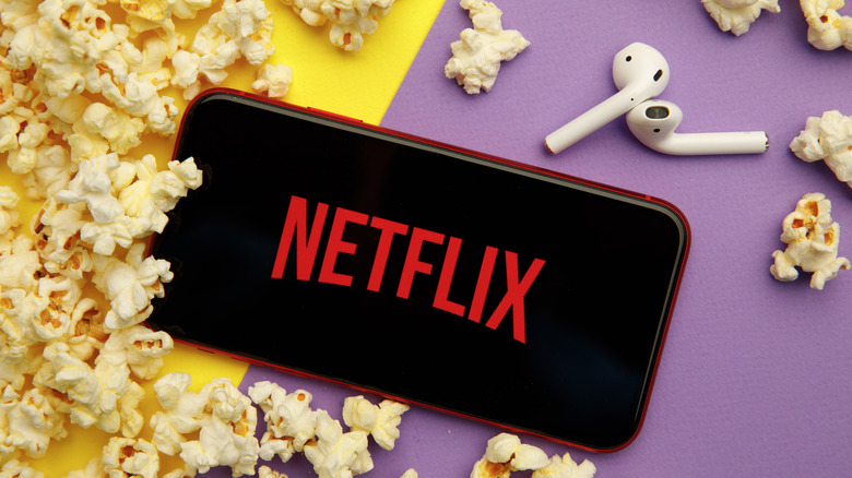 Netflix on iPhone with AirPods and popcorn