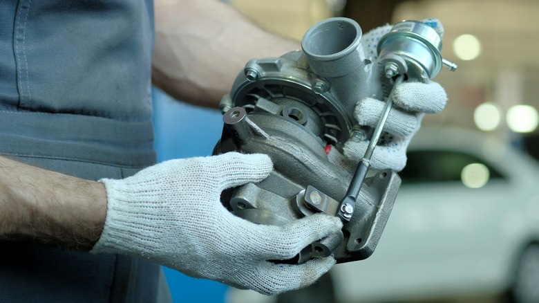 mechanic holding turbocharger