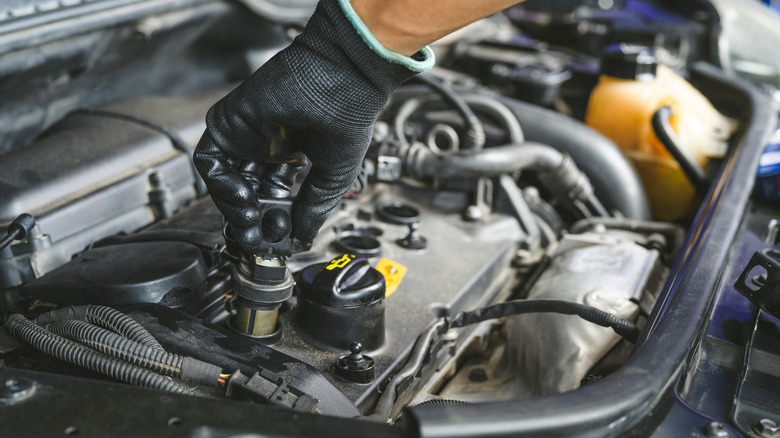 Mechanic installing new coil packs