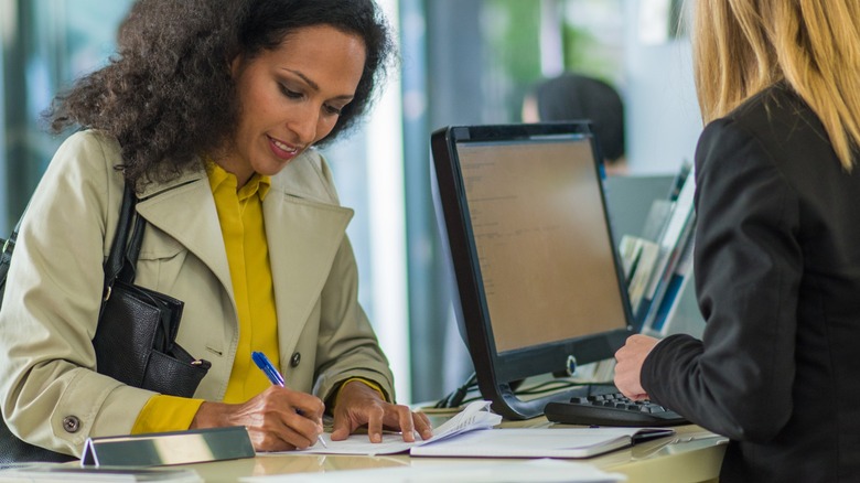 A woman filling a form at the counter