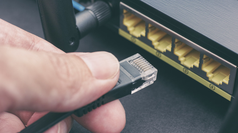 person plugging cable into router