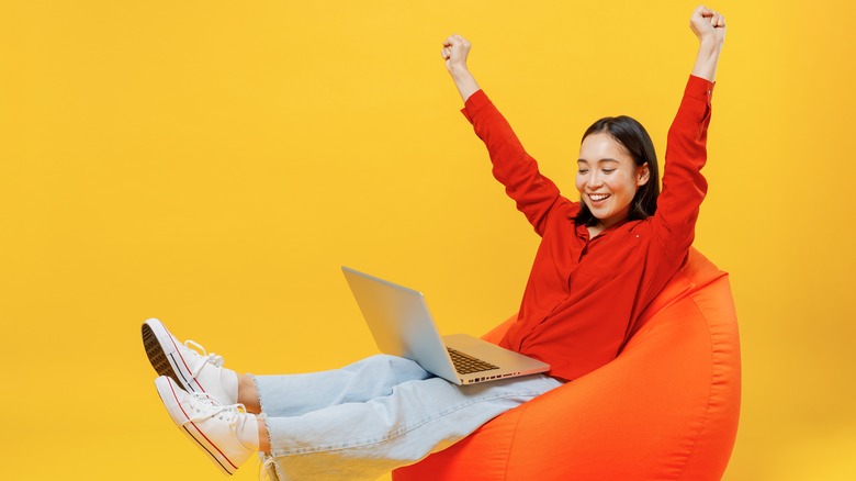 Happy with laptop in beanbag chair