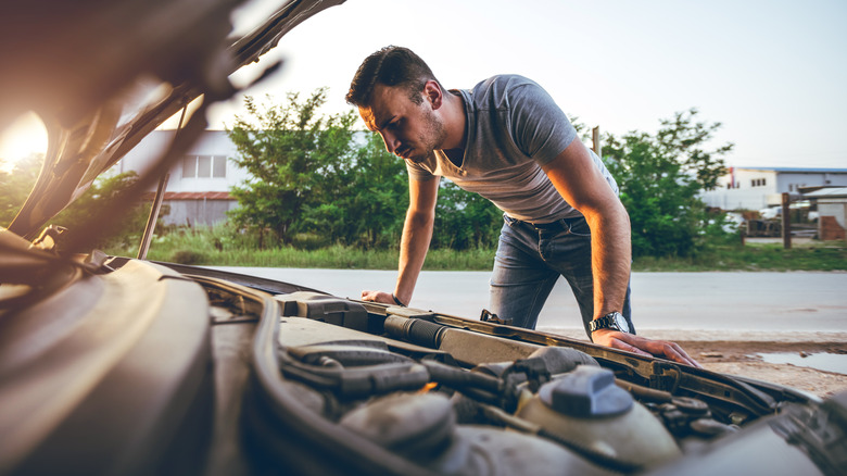 Man looking at car engine