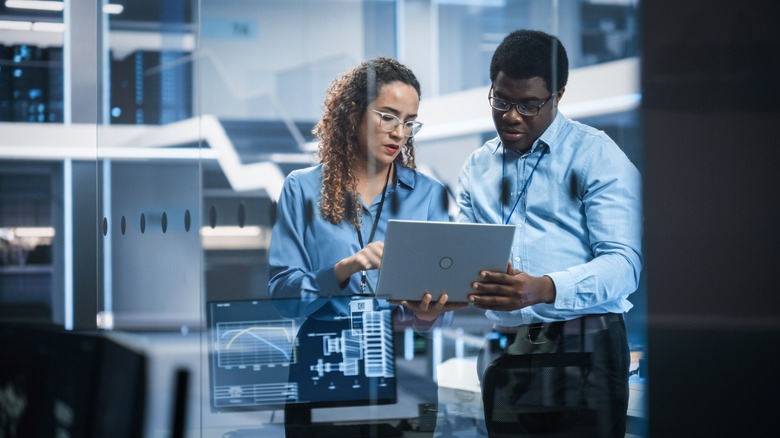 two scientists looking at a tablet