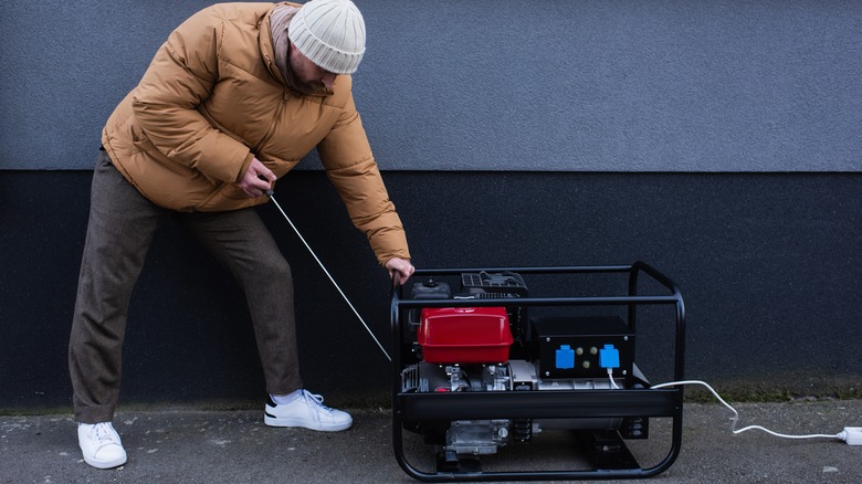 Man starting portable generator