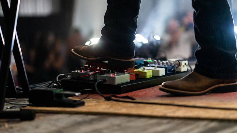 person using guitar pedalboard