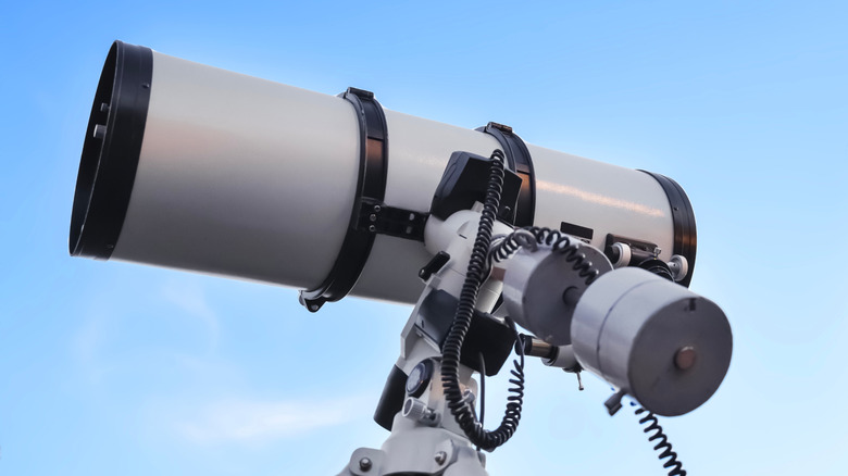 A telescope observing a cloudless blue sky.