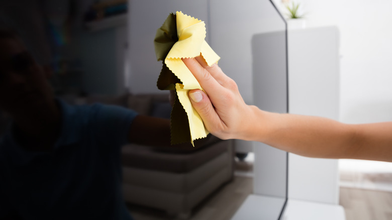 woman cleaning TV screen