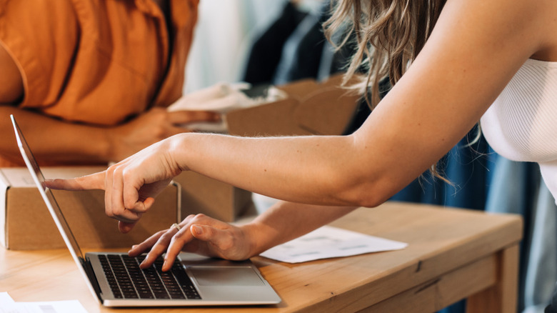 woman pointing at laptop with box