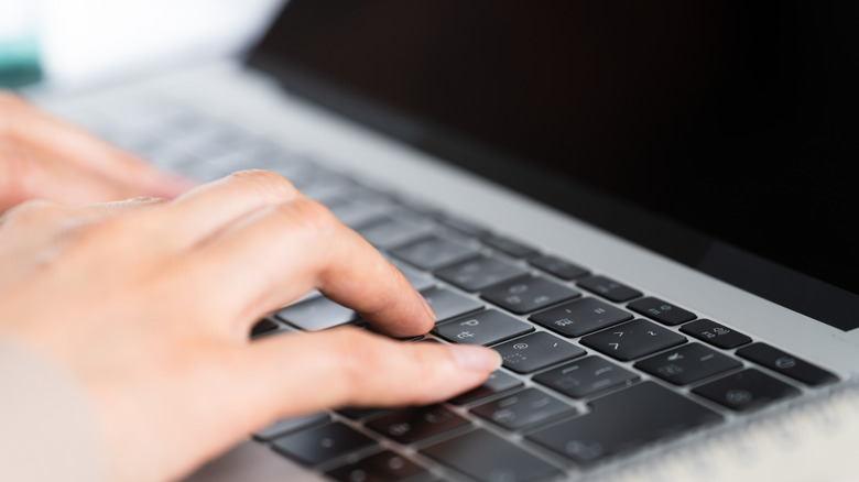 hands on laptop keyboard