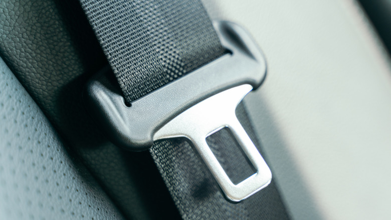 A car seat belt resting against a seat