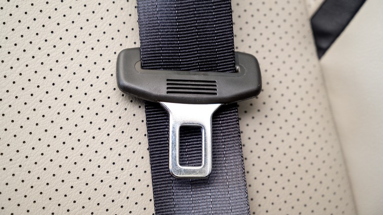 A car seat belt resting against a seat