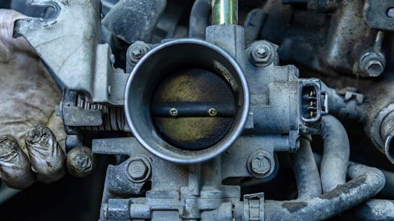 a closeup image of a dirty engine throttle body