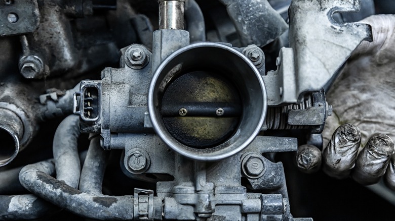 a closeup image of a dirty engine throttle body