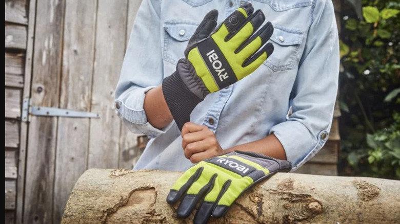 Person wearing Ryobi safety gloves