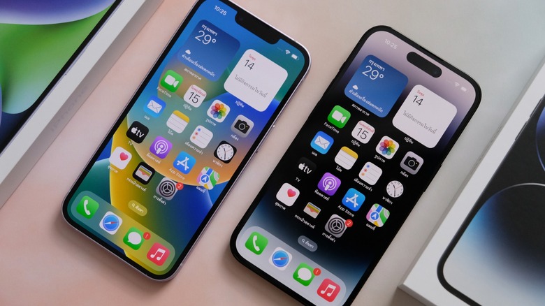 Two iPhones next to each other on a white desk. 