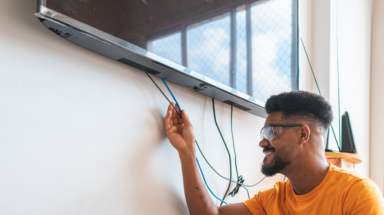 man fixing LAN cable in TV